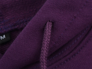 Detail of dark purple hoodie fabric texture with woven drawstring and size M tag