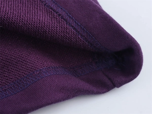 Close-up of double-needle stitching and purple terry cloth texture on cotton hoodie