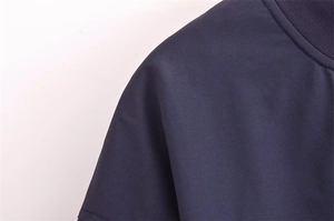 Detailansicht des Rippstrickkragens und des dunkelblauen Stoffes der Baseballjacke