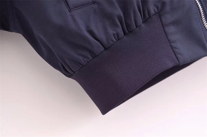 Detail der dunkelblauen Baseballjacke mit geripptem Saum und Präzisionsreißverschluss