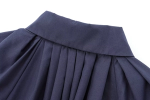 Nahaufnahme der marineblauen Popeline-Bluse mit Falten am Bund und feiner Stoffstruktur