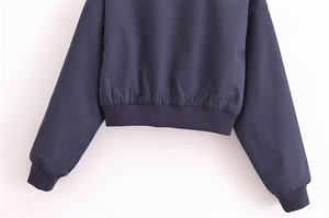 Detailansicht der dunkelblauen Bomberjacke mit elastischem Rippsaum und gewebter Textur