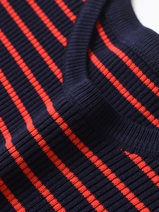 Dettaglio macro di maglia a righe blu e rosse con trama a costine e cuciture rifinite