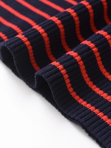 Dettaglio ravvicinato della trama in maglia a coste a righe blu navy e rosse