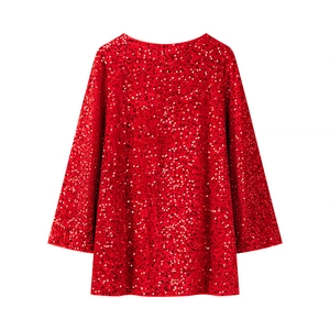 Détail d'une robe rouge à paillettes avec manches longues pour soirées festives
