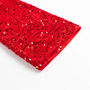 Gros plan des paillettes rouges scintillantes sur le tissu en velours de la robe de soirée