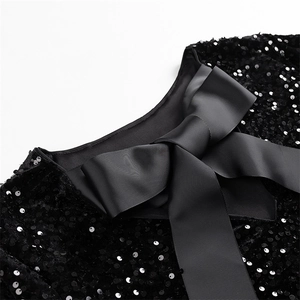 Gros plan détaillé d'une robe noire à paillettes avec un grand nœud élégant sur l'encolure