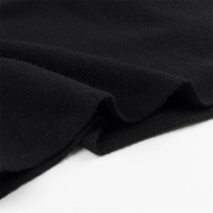 Détail de la texture d'un tricot noir avec des fibres de laine douce sur un pull sans manches