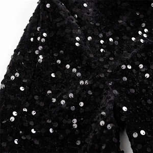 Gros plan détaillé de paillettes noires brodées sur une texture de tissu en velours