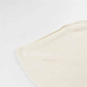 Gros plan sur la texture en maille fine et le tissu en laine blanc cassé de ce haut chic