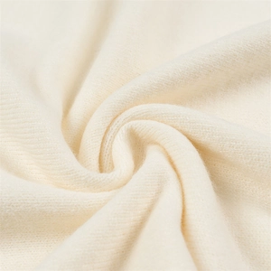 Texture détaillée du tricot blanc cassé montrant les fibres de laine douces et tissage