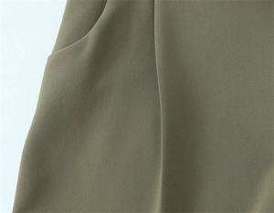 Dettaglio dei pantaloni dritti verde oliva con tasca laterale e trama del tessuto