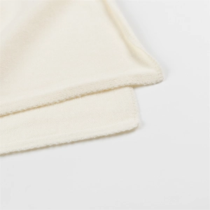 Gros plan sur la texture douce et les coutures fines du tissu en maille blanc crème