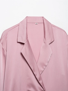 Detail van roze satijnen blazer kraag met getextureerde stof en XS-maatlabel binnen