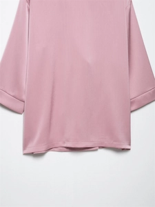 Detail van roze satijnen blazer met verticale textuur en brede halflange mouwen