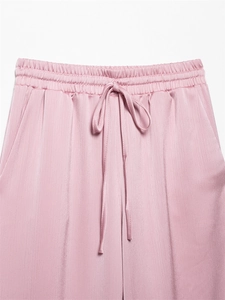 Detail van roze kreukbroek met hoge taille, elastische trekkoord tailleband en steekzakken