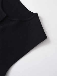 Close-up of black knitted fabric texture with premium ribbed edge detail on vest