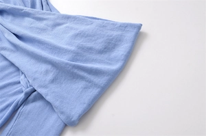 Detailed macro view of light blue knit sleeve cuffs with fine fabric texture and quality