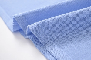Macro shot of light blue knit fabric showing soft texture and detailed stitching