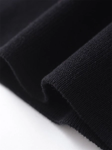 Close-up of black knitted fabric texture showing thick soft weave on a halter neck vest