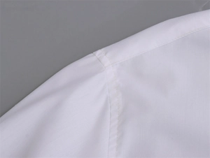 Vue détaillée des coutures professionnelles sur l'épaule d'une chemise blanche