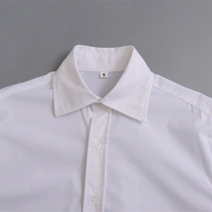 Gros plan sur le col d'une chemise blanche minimaliste avec boutons et étiquette S