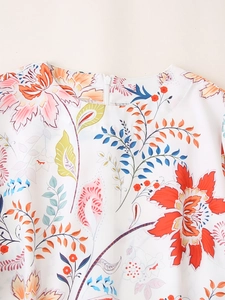 Detail von Rundhalsausschnitt und Rückenreißverschluss am weißen Kleid mit Tropenmuster
