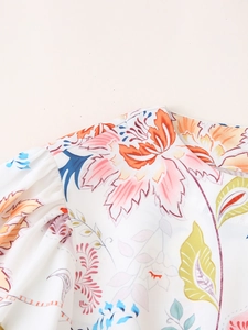 Detail von Rundhalsausschnitt und Schulterfalten am weißen Sommerkleid mit Blumen