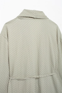Detailed back view showing the quilted texture and tie-waist of the light green top