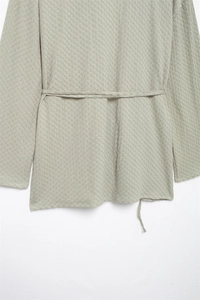 Detail shot of light green waffle textured fabric with drawstring waist design