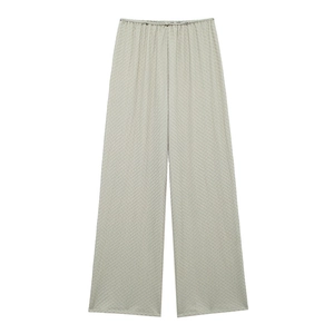 Detailed view of light green textured fabric on high-waisted wide-leg elastic trousers