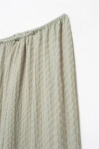 Close-up of elastic waistband and breathable seersucker texture in light green