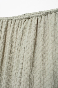 Detail shot of the textured olive green waffle fabric with premium elastic seam finish