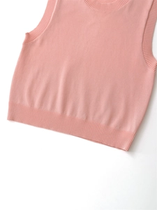 Detail of pink knitted vest showing ribbed neckline and high-quality fabric texture