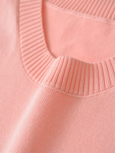 Close-up of pink knit vest showing round neck detail and ribbed collar texture