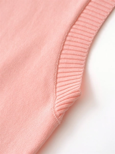 Detail of pink sleeveless knit vest showing high-quality ribbed texture and elastic hem