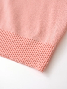 Close-up of pink knit vest showing fine texture and ribbed hem detail for a quality look