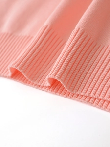 Close-up of pink knit vest showing high-quality ribbed hem texture and soft fabric