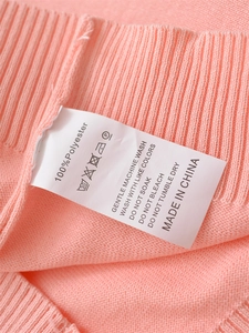 Detail showing the 100% polyester fabric label and fine rib-knit texture of the pink top