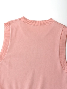 Detailed close-up of light pink knit vest showing high-quality ribbed collar and armhole texture