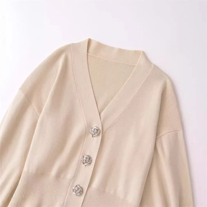 Chic cream knit cardigan with V-neckline and elegant rose-shaped metal buttons
