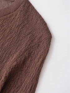 Detailed view of dark brown crochet knit cardigan showing hollow out texture and round neck