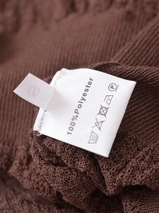Detailed laundry label of a brown polyester cardigan showing size S and washing instructions