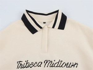 Detail eines gestrickten Polokragens mit schwarzen Streifen und Tribeca Midtown-Stickerei
