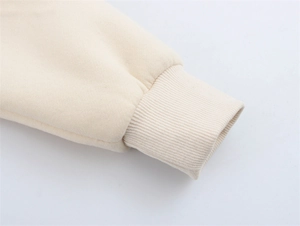 Detail der gerippten Manschetten am cremefarbenen Sweatshirt mit Stoffstruktur
