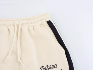 Detail der elastischen Kordelzug-Taille und schwarzer Seitenstreifen an beige Tribeca Jogginghose