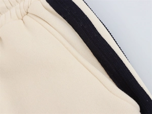 Detail der cremeweißen Jogginghose mit elastischem Bund und seitlichem Streifen
