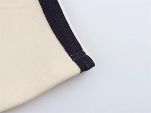 Nahaufnahme von cremefarbenem Sweatshirt-Stoff mit dunkelblauen Streifenbündchen