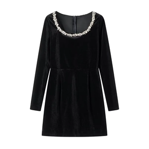 Detail of elegant rhinestone leaf embellishments on a black velvet dress neckline