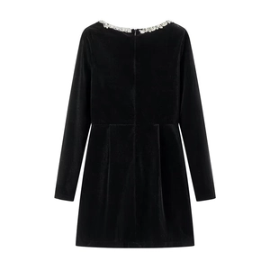 Detailed back view of a black velvet dress featuring invisible zipper and waist pleats